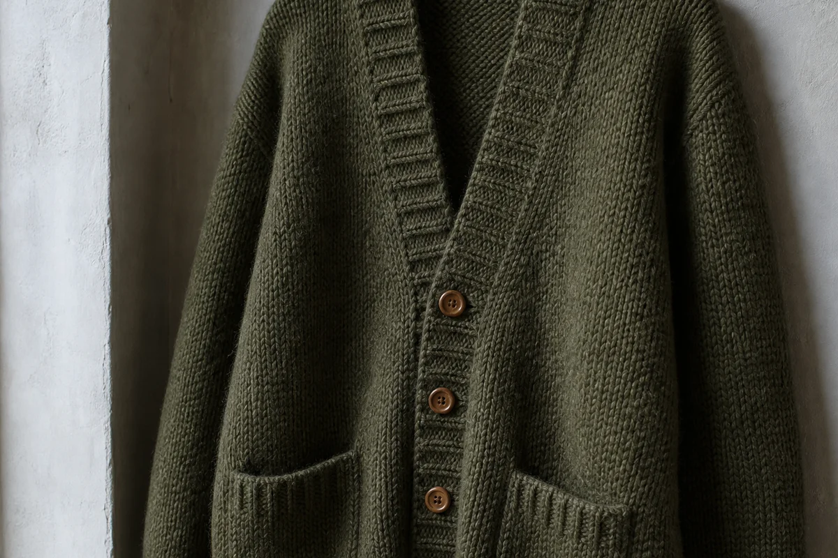 Chaqueta larga con bolsillos y botones de madera tejido en el taller Haverlind